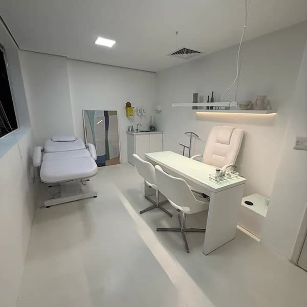 Sala de avaliação com maca, mesa e iluminação suave