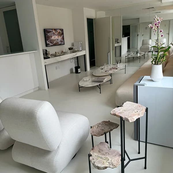 Recepção da Elvare, com poltronas brancas, orquídea e bancada de mármore