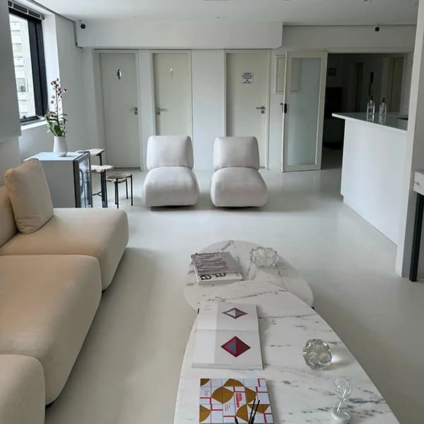 Sala de espera da Elvare, com sofás claros e mesa de mármore