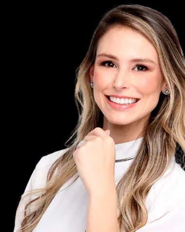 Dra. Yasmin Carvalho, de blusa branca, sorrindo